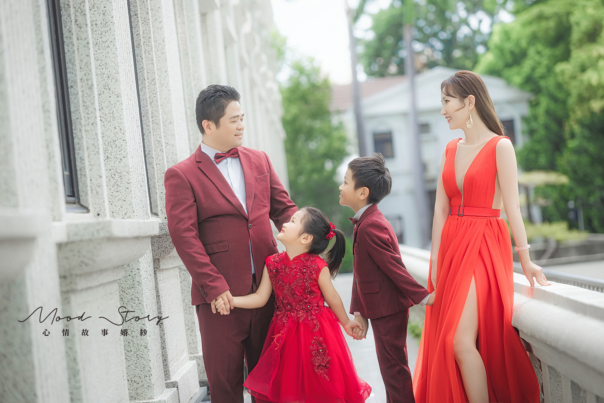 高雄外拍全家福，父母與孩子穿紅禮服在橋邊拍攝的質感家庭合照｜Mood Story